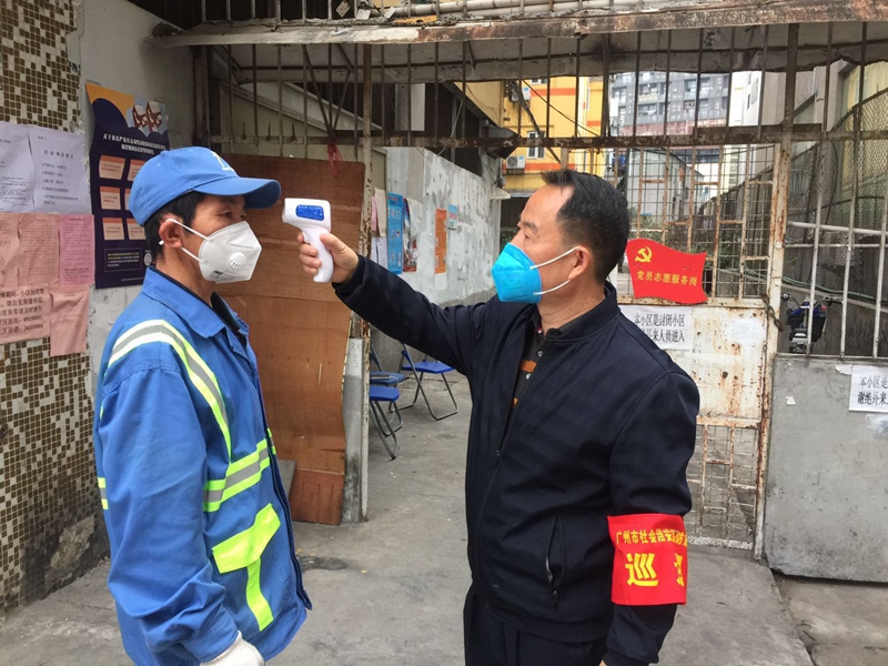 陈平安在志愿者岗位，为进出的居民测量体温.jpg